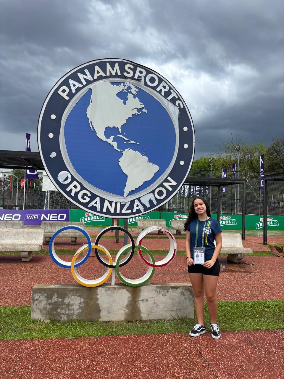 Yasmin ao lado do símbolo da Panam Sports com os anéis olímpicos
